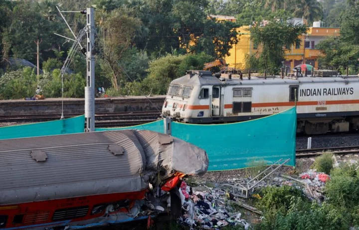 India opens rail disaster probe as trains crawl through crash site