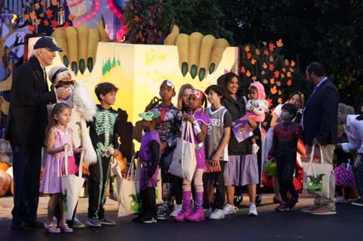 Biden and Jill Biden hand out books and candy while hosting thousands for rainy trick or treating