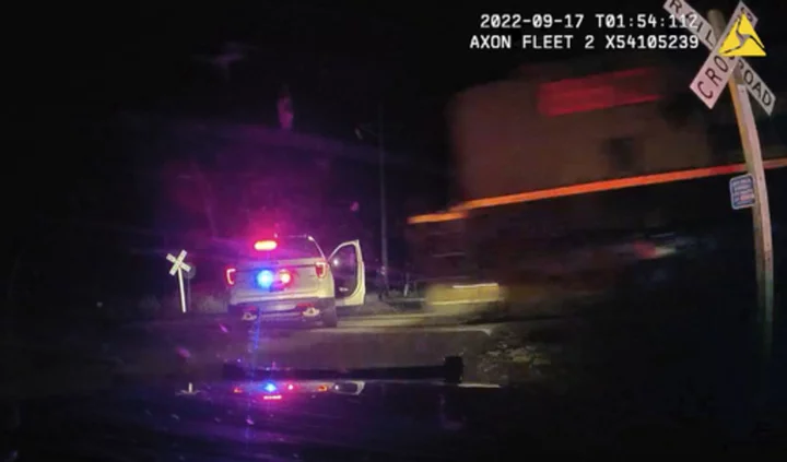 Officer who put woman in a police car hit by a train didn't know it was on the tracks, defense says