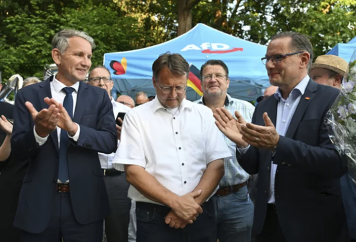 After a far-right victory in German county, a man in neo-Nazi clothing hands balloons to children